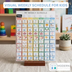 May include: A clear acrylic visual weekly schedule board for kids with a wooden base. The chart features columns for each day of the week, labeled with colorful headers and rows of small square icons representing daily tasks like wake up, school, and bedtime.
