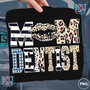 May include: Black graphic featuring the words "MOM DENTIST" with a lip design. The letters have various patterns, including stripes, leopard print, and teeth. The image is held by a hand.
