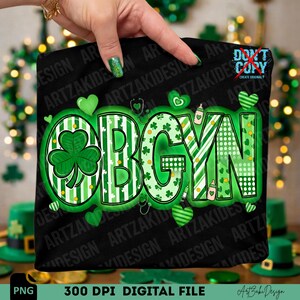 May include: Black t-shirt with the word "OBGYN" in green, decorated with shamrocks and hearts. The design includes stripes, polka dots, and medical-themed elements. The image also includes the text "300 DPI DIGITAL FILE".