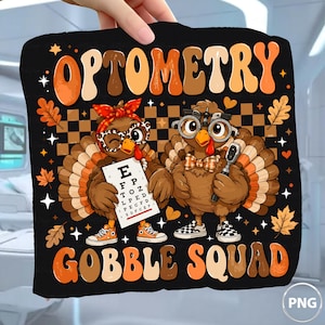 Puede incluir: Un estampado gráfico negro con el texto OPTOMETRY y GOBBLE SQUAD en una fuente retro naranja y marrón. Se muestran dos pavos de dibujos animados; uno lleva una diadema roja y gafas, sosteniendo una tabla optométrica, y el otro una pajarita.