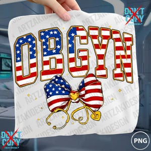May include: White t-shirt featuring the word "OBGYN" in red, white, and blue, styled like the American flag. A bow with a heart and stethoscope design is below the text. The design includes gold accents and stars.