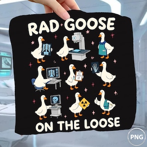 May include: A black graphic t-shirt featuring the text RAD GOOSE ON THE LOOSE and illustrations of white geese performing various radiology tasks, including operating an X-ray machine, reviewing scans, holding a report, and wearing a lead apron.