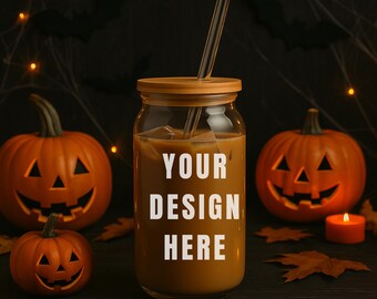 May include: A glass jar with a wooden lid and straw, filled with a brown liquid, and the text "YOUR DESIGN HERE". The jar is surrounded by carved orange pumpkins, autumn leaves, and a lit candle, with a dark background.