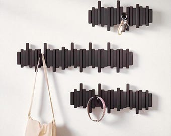 Perchero de pared de madera negra con modernos ganchos magnéticos abatibles