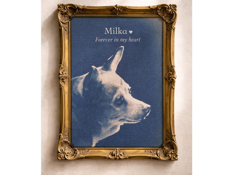 May include: A framed portrait of a dog named Milka, with the text "Forever in my heart." The dog is depicted in profile against a blue background. The ornate gold frame adds a touch of elegance.