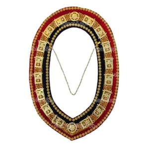 May include: An ornate ceremonial collar with a red, black, and gold design. The collar features intricate gold-colored embellishments and a delicate chain. The overall design is symmetrical and formal, suitable for ceremonial use.