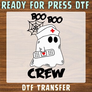 May include: A DTF transfer featuring a white ghost wearing a nurse cap with a red cross, holding a bandage with a red heart. Above the ghost is a spider web and the text BOO BOO, and below is the text CREW. The top text reads READY FOR PRESS DTF.