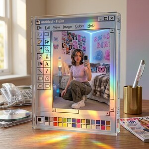 May include: A clear acrylic mirror designed to resemble a Windows Paint window. The mirror reflects a room with a person taking a selfie. The mirror has a colorful rainbow effect and includes the text "untitled - Paint".