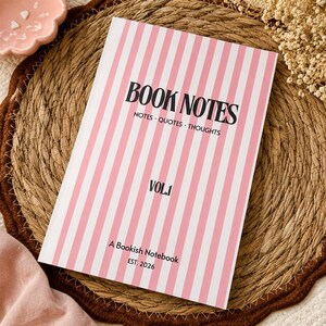 Pode incluir: Um caderno retangular com uma capa de listras verticais rosa e brancas. O texto diz BOOK NOTES, NOTES · QUOTES · THOUGHTS, VOL.1, A Bookish Notebook e EST. 2026 em fontes pretas serifadas e sem serifa na capa frontal.