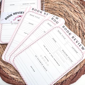 May include: A set of pink and white book review cards with a scalloped border. Each card has sections for book title, genre, author, and a rating. The words "Book Review" are printed on the cards.