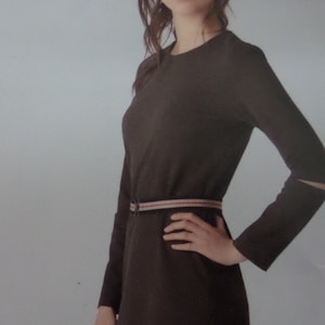 May include: A dark brown dress with long sleeves and a belt. The dress has a round neckline and a belt with red and white stripes. The sleeves have a small slit near the wrist. The dress is made of a soft, flowing fabric.
