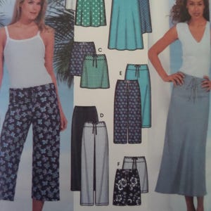 May include: A sewing pattern envelope featuring illustrations of various pants and skirts. Designs include wide-leg pants with butterfly prints, striped trousers, solid-colored skirts, and floral-patterned shorts, all with drawstring waistbands.