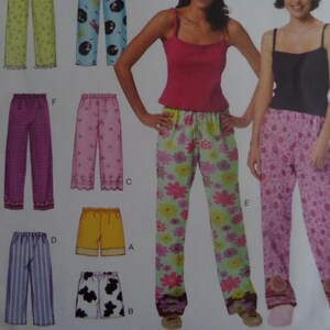 May include: A sewing pattern illustration featuring various pajama bottoms and shorts in multiple colors and patterns, including floral prints, stripes, and cow spots, alongside two tank tops in solid pink and black, labeled with letters A through F.