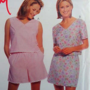 May include: Two sets of clothing. Set A is a sleeveless V-neck top and shorts in a light pink gingham pattern with scalloped edges. Set B is a short-sleeved V-neck top and a skirt featuring a light blue background with a multi-colored floral print.