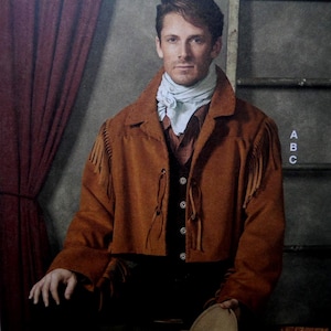 May include: A brown suede jacket with fringe detail, worn over a vest and collared shirt. The jacket has a cropped design and is fastened with leather ties. A light blue scarf is worn around the neck. The image has the letters "A", "B", and "C" on the right side.