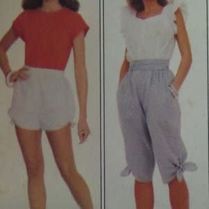May include: A red short-sleeved top paired with white shorts, and a white sleeveless top with ruffled shoulders paired with light blue cropped trousers featuring a high elasticized waistband and tied cuffs at the bottom of each leg.