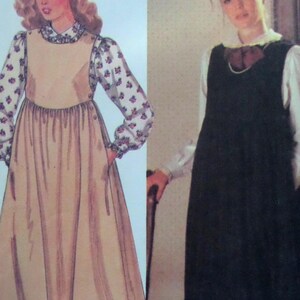 May include: A sewing pattern illustration showing two variations of a long-sleeved dress. The left side features a beige dress with floral patterned sleeves and a high collar. The right side shows a black sleeveless dress worn over a white blouse.