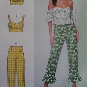 May include: A sewing pattern featuring a two-piece outfit and a pair of pants. The outfit includes a top with a white floral pattern on a green background, and matching pants. The other pattern options include a yellow floral top and yellow gingham pants.