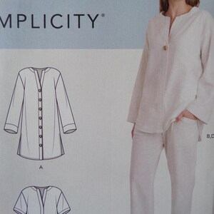 May include: A Simplicity sewing pattern envelope featuring a technical line drawing of a long-sleeved tunic with a button-front placket and side slits, alongside a photograph of a person wearing a matching off-white long-sleeved shirt and pants.