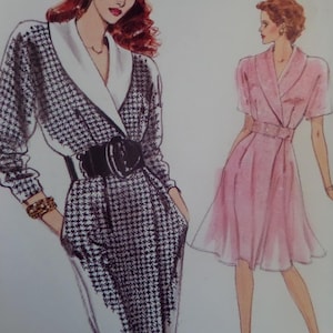 May include: Illustration of two dresses. One is a black and white houndstooth print wrap dress with a black belt. The other is a pink dress with a matching belt. Both dresses have a V-neck design.