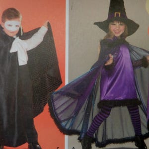 May include: A costume set featuring a black cape with a white mask and shirt, alongside a purple dress with a black cape, a pointed hat with a gold buckle, and black and purple striped leggings, designed for theatrical or holiday dress-up play.
