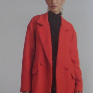 May include: A vibrant red double-breasted coat with a classic lapel collar. The coat features two rows of buttons and a tailored fit. The model is wearing a black turtleneck underneath. The coat is a bold fashion statement.
