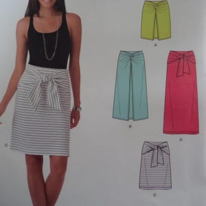 May include: A woman wearing a black tank top and a white and gray striped skirt with a bow. The image also shows illustrations of different skirt styles in green, blue, and pink.