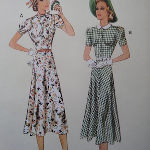 May include: Vintage dress patterns. One dress is white with a floral print, a brown belt, and short sleeves. The other dress is green and white checkered with a white collar, short sleeves, and a white belt. Both dresses have a button-down front.