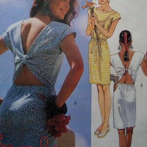 May include: A sewing pattern illustration featuring two dress styles. One is a blue dress with a white geometric pattern and a back tie detail. The other is a yellow and white striped dress with a gathered waist and a solid white back-tie dress.