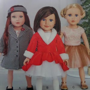 May include: Three dolls are displayed, each with different outfits and hairstyles. One doll wears a black and white houndstooth coat, another a red dress with white trim, and the third a pink top and brown tulle skirt. All dolls have blue eyes.