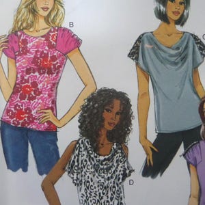 May include: Illustration of four different tops. One top is pink with a floral pattern and pink sleeves. Another is a light blue top with lace sleeves. The third top is a black and white animal print. The fourth top is purple.