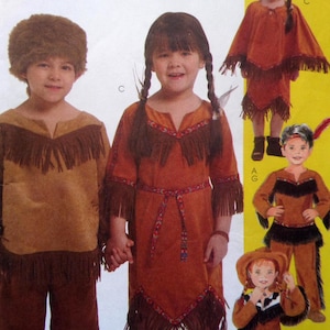May include: A sewing pattern envelope featuring illustrations of children wearing brown faux suede costumes with fringe detailing, patterned trim, and accessories including a fur-textured hat and a poncho, displayed against a bright yellow background.