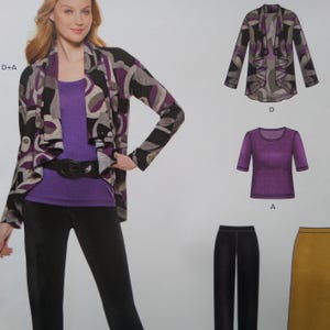 May include: A woman wearing a purple top, black pants, and a patterned jacket with black, gray, and purple swirls. The jacket is open, revealing the top and a black belt. Additional clothing items are displayed.
