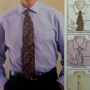 May include: A light blue long-sleeved button-up shirt with a chest pocket, paired with a dark brown patterned necktie and a black belt. To the right, technical illustrations show shirt collar variations labeled BUTTON DOWN and SPREAD.
