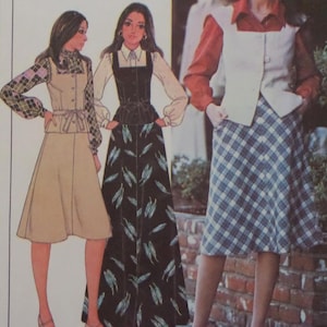 May include: A sewing pattern illustration featuring three outfits: a beige vest with a plaid blouse and skirt, a black bodice with a white shirt and a long black skirt with a leaf print, and a white vest over a rust-colored shirt with a blue plaid skirt.