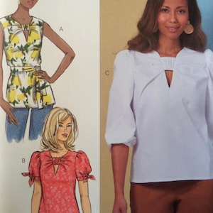 May include: Illustration of three different blouses. One is a sleeveless top with a lemon print, another is a red blouse with short sleeves, and the third is a white blouse with long sleeves. All blouses have a keyhole neckline.
