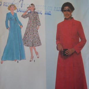 May include: A sewing pattern envelope featuring illustrations of three robe styles. One is a solid blue floor-length wrap robe, one is a floral print knee-length robe, and one is a solid red long-sleeved robe with a high collar and side closure.