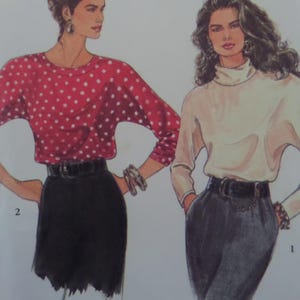 May include: A fashion illustration showing two outfits. Outfit 2 features a red long-sleeve top with white polka dots and a black skirt with a black belt. Outfit 1 features a cream turtleneck top and dark gray trousers with a black belt.