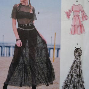 May include: A white ceramic mug with a black handle and the text "But First, Coffee" in a black, bold font. The mug is on a white surface.