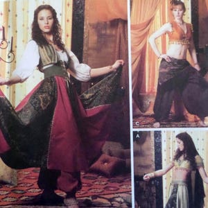May include: A sewing pattern illustration featuring three outfits: a white blouse with a green corset and a long red and dark green patterned skirt, a cropped orange top with dark patterned harem pants, and a cropped top with a long patterned skirt.