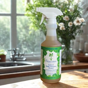 Pode incluir: Uma garrafa de spray de plástico transparente de Florassence Natural Multi-Purpose Cleaner. A garrafa tem um borrifador branco e um rótulo verde e branco com texto e um desenho de folha. A garrafa contém 473 ml de produto de limpeza.