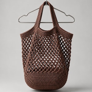 May include: A dark brown crochet tote bag featuring a diamond-shaped open mesh pattern on the body and a solid, tightly stitched oval base. The bag includes two integrated handles and is suspended from a silver-colored metal clothes hanger.