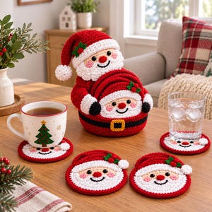 Puede incluir: Un soporte de ganchillo con forma de Papá Noel que contiene un juego de posavasos redondos de ganchillo. Cada posavasos presenta una cara sonriente de Papá Noel con gorro rojo, barba blanca y hojas de acebo verdes.