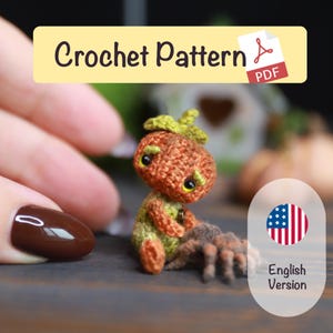 May include: A crocheted pumpkin-like figure with a green stem and yellow eyes, sitting next to a small spider. The figure is orange and green. The image includes the text "Crochet Pattern PDF".