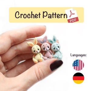 Könnte beinhalten: Drei kleine, gehäkelte Hasenfiguren in Pastellfarben: Gelb, Rosa und Blau. Jeder Hase hat lange Ohren und eine kleine orangefarbene Schleife. Das Bild enthält den Text "Crochet Pattern PDF".
