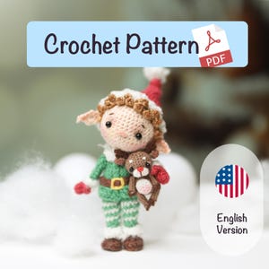 Pode incluir: Uma boneca elfo de crochê com uma roupa verde e calças listradas verdes e brancas, segurando uma pequena rena. O elfo tem um chapéu vermelho e branco e um cinto marrom. Inclui o texto "Crochet Pattern PDF".