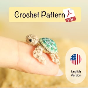 May include: A tiny, crocheted turtle with a tan body and a green and blue shell. The image includes the text "Crochet Pattern" and a PDF icon. An American flag graphic with the words "English Version" is also present.
