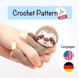 Puede incluir: Un títere de dedo de perezoso tejido a ganchillo en tonos marrones, beige y blanco. El perezoso tiene ojos grandes y expresivos y se sostiene en una mano. La imagen incluye el texto "Crochet Pattern PDF".