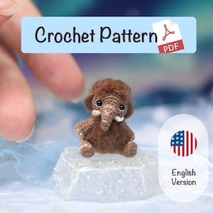 Può includere: Un giocattolo di mammut lanoso marrone all'uncinetto con zanne bianche e una testa soffice. L'immagine include il testo "Crochet Pattern PDF" e "English Version" con la bandiera americana. Il giocattolo è su una superficie ghiacciata trasparente.