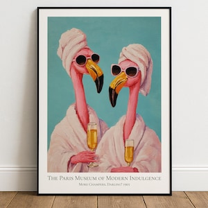 May include: Art print in a black frame showing two flamingoes in sunglasses and white bathrobes, holding champagne glasses. The background is teal. The text at the bottom reads "The Paris Museum of Modern Indulgence".